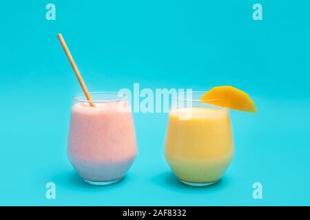 Traditional indian Mango Lassi and Strawberry Lassi drinks in glass cups on blue background, copy space Stock Photo