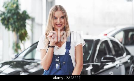 Always happy to see our customers. Nice blonde woman repairer is on her work. Indoors at car shop Stock Photo