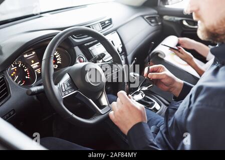 Get ready. Assistant manager giving advices and help to the customer in automobile salon Stock Photo