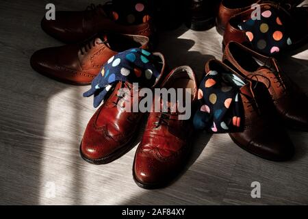 stylish men's socks. Stylish suitcase, men's legs, multicolored socks and new shoes. Concept of style, fashion, beauty and vacation. Stock Photo