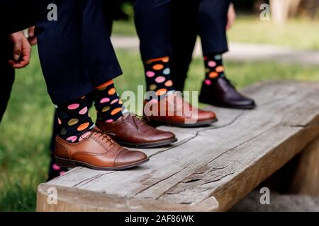 stylish men's socks. Stylish suitcase, men's legs, multicolored socks and new shoes. Concept of style, fashion, beauty and vacation. Stock Photo