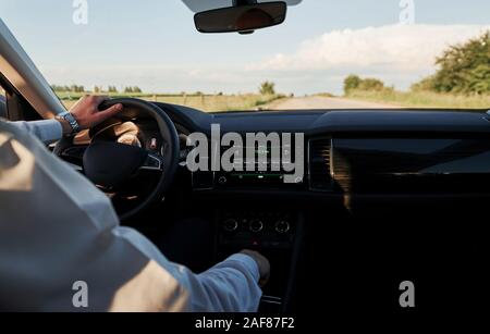 On the road. Driver feels good in his brand new car. Riding at sunny day Stock Photo