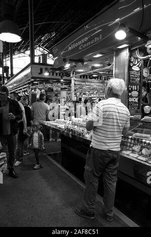 Monochrome image of market stalls selling various drinks and produce within the Mercado de La Boquerioa in Barcelona. Stock Photo