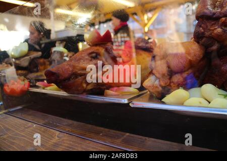 Budapest, Hungary - December 8, 2019: pig head of a roasted pork with apples on display at a market stall on one of Budapest's christmas markets. Stock Photo