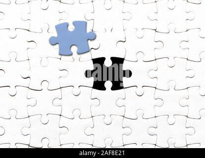 top view of white blank jigsaw puzzle with one piece taken out Stock Photo