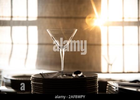 Empty glass cup with sun flares background in a restaurant. Stock Photo