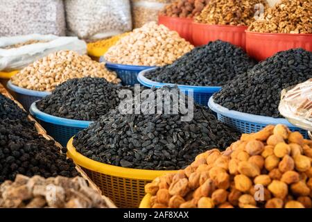 View of colorful raisins and apricot in basins on showcase of local food market, Uzbekistan Stock Photo