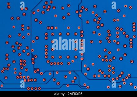 a back side of classic blue color curcuit board flat background without any components - only copper contact holes Stock Photo