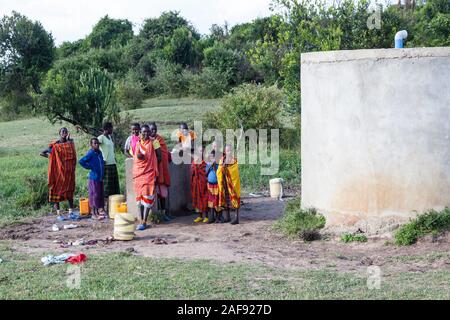 Tanzania.  Serengeti.  Maasai Villagers of Ololosokwan at Water Storage Facility. Stock Photo