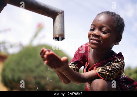 Close up Photograph of African Black Girl Drinking Safe Water from Tap Stock Photo