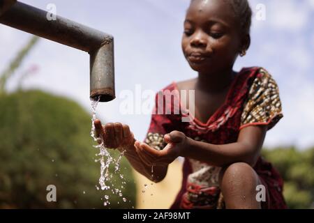 Hand Finger Under Tap with Water from a Black Child of Native African Ethnicity Stock Photo