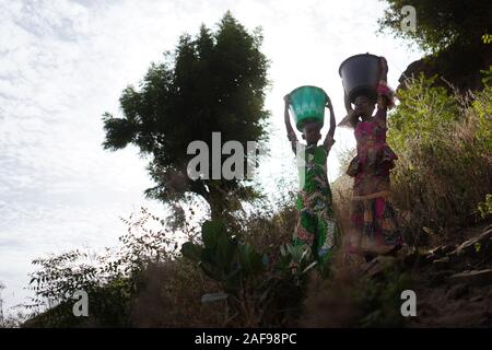 Child Labour Labor Symbol, African Girls Women Working with Water Buckets Stock Photo