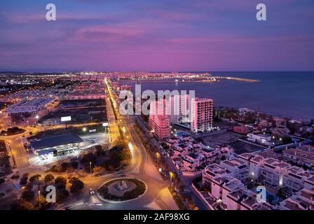 Aerial photo top view of Torrevieja spanish resort city during sunset purple violet colour cloudy sky, picturesque sundown, Province of Alicante, Cost Stock Photo