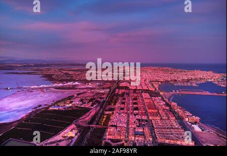 Aerial photography picturesque sunset over Torrevieja spanish resort town evening purple violet cloudy sky. Salt Lake and Mediterranean Sea, townscape Stock Photo