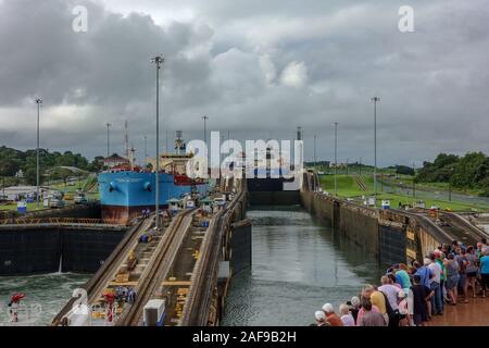 Panama - 11/6/19: A cruise ship with the passengers on the bow watching the ship entering the first lock of the Panama Canal. Stock Photo