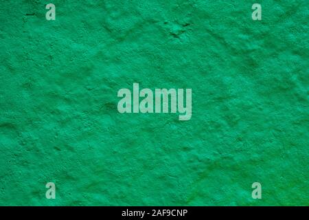 texture of a painted wall. cement plate green color background. wall with bumps and small pits. Stock Photo