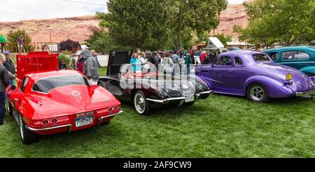 A restored and modified black 1958 Chevy Corvette in the Moab April Action Car Show in Moab, Utah.  At left is a 1976 Corvette Stingray.  At right is Stock Photo