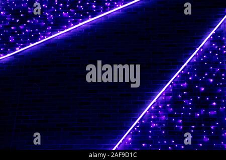 Neon blue light against the background of a brick wall. Abstract background of deep blue color. Stock Photo