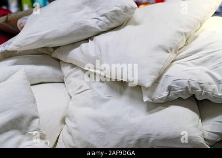 A lot of white soft down pillows lie on top of each other. Stock Photo