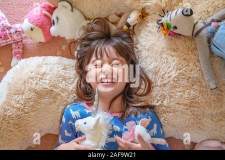 Seven year old girl playing with her toys Stock Photo