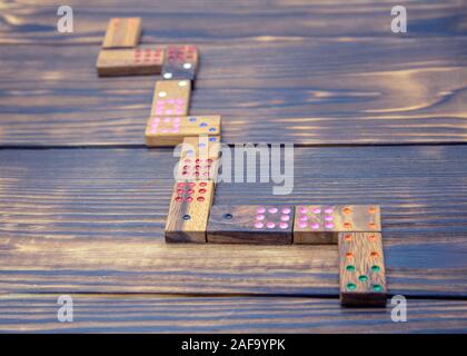 Playing dominoes on a wooden textured table. Stock Photo