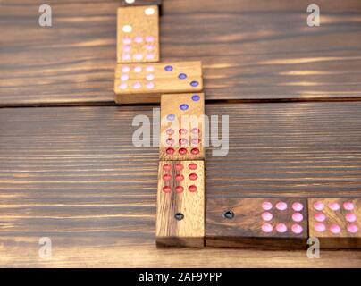 Playing dominoes on a wooden textured table. Stock Photo