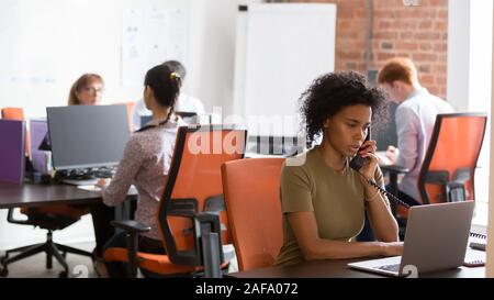 Diverse employees working in modern room sitting in shared office Stock Photo