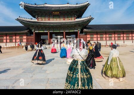 Seoul, South Korea - November 28th, 2019: Tourists wearing traditional Korean Hanbok dress and visiting the Gyeongbokgung palace on a sunny winter day Stock Photo