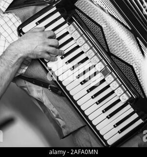 Accordionist plays vintage accordion, stylized square black and white photo Stock Photo