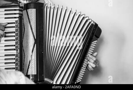 Accordionist plays vintage accordion. Retro stylized black and white photo Stock Photo