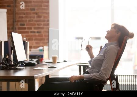 Side view relaxed businesswoman resting leaning on comfortable office chair Stock Photo