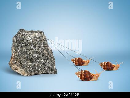 Team work concept, snails pulling big rock Stock Photo