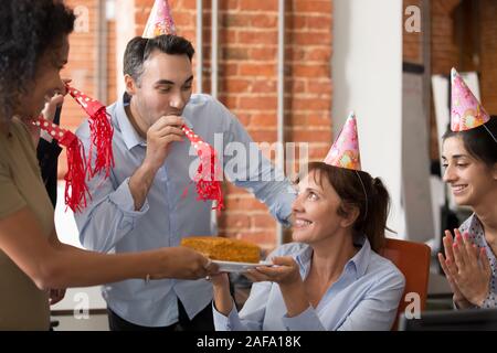 Diverse cheerful friendly employees congratulating mature colleague happy birthday Stock Photo