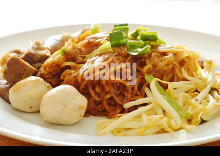 dried thin rice noodle topping braised pork dressing cayenne pepper on dish Stock Photo