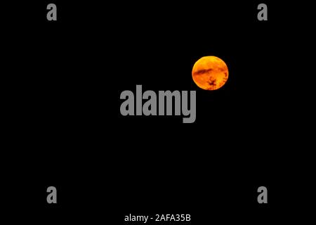 The full moon with lunar spots stands out against the night sky Stock Photo