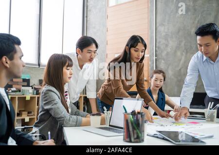 Group of Asian business people team meeting in modern office working design planning and ideas concept Stock Photo