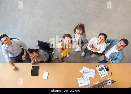 Top view portrait of Asian creative business team. Hipster Creative Startup Young business people in modern office. Stock Photo