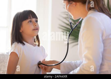 Pediatrician with stethoscope listening to lung and heart sound of child Stock Photo