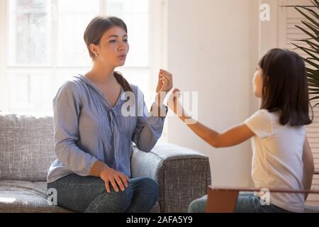 Female speech therapist doing exercise, speaking with little girl patient Stock Photo