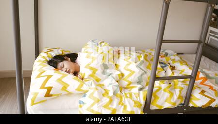 little asian girl sleep on bunk bed in bed room Stock Photo