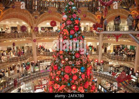 The Christmas tree and display in Galeries Lafayette, an upmarket department store in Paris France with amazing stained glass roof Stock Photo