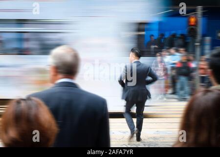 HongKong, China - November, 2019: Blurry image of businessman crossing street in Hong Kong business district Stock Photo
