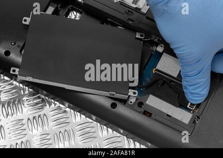 Technician connecting hard drive HDD cable to a laptop computer.  Computer updrade concept Stock Photo