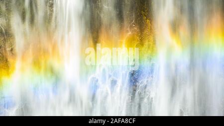(Selective focus) Close-up view of the Tumpak Sewu Waterfalls with a beautiful rainbow formed by refraction of light in water droplets. Stock Photo