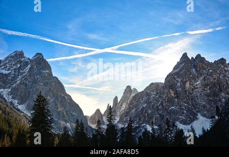 The trails left by the airplanes cross over the mountain peaks of the Val Fiscalina