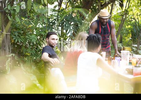 Group of people toasting beers celebration and having barbecue party outdoors garden Stock Photo