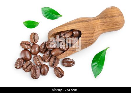 Heap of roasted coffee beans in wooden scoop with leaves isolated on white background. Top view. Flat lay. Stock Photo