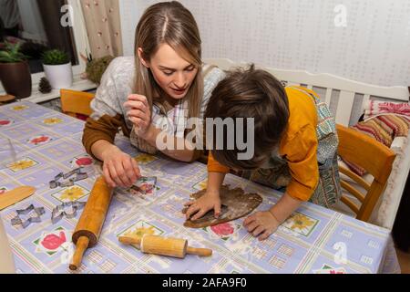 Mother and son making gingerbread cookies in the kitchen for Christmas, picture from Northern Sweden. Stock Photo