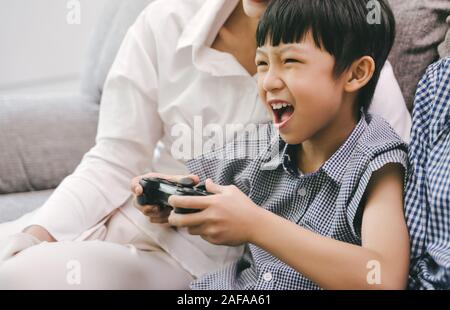 Son and parent family playing video game at home Stock Photo
