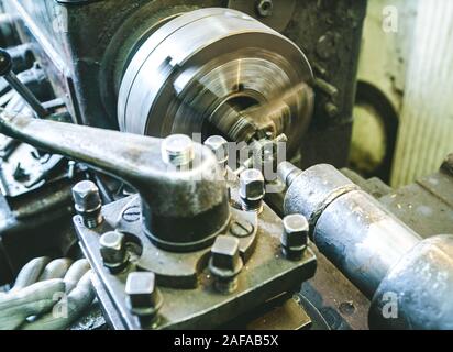 Close-up of hand in glove and lathe. Thread cutting on a stud. Metalwork equipment. Stock Photo